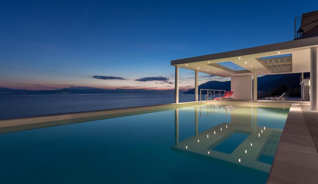 a house with a swimming pool at night at Super Luxurious Villa - 600m² - Up to 22 people in Edipsos