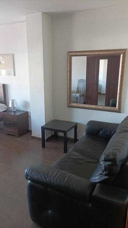 sala de estar con sofá y espejo en Apartamento Jean Pool, en Alcantarilla