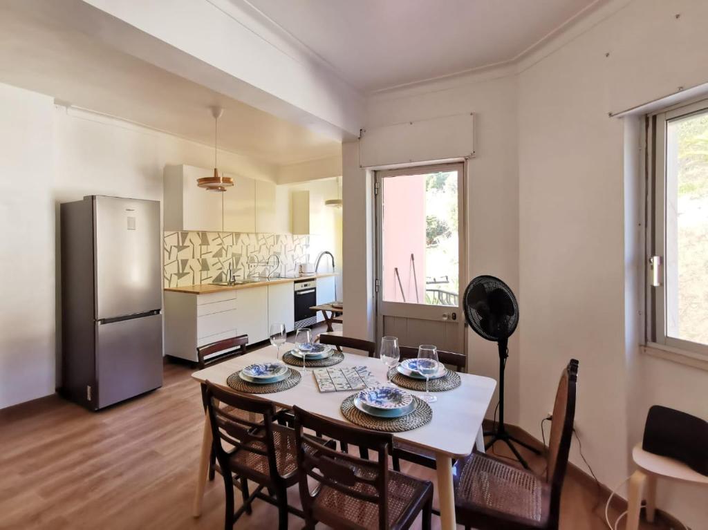 een keuken met een tafel en stoelen en een koelkast bij Fonte Park in Setúbal