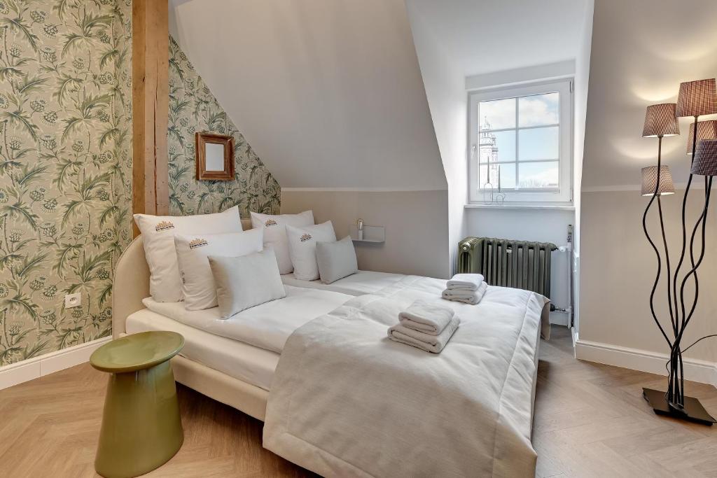 a bedroom with a white bed and a window at Downtown Apartments The Love Bridge - Na Piaskach in Gdańsk