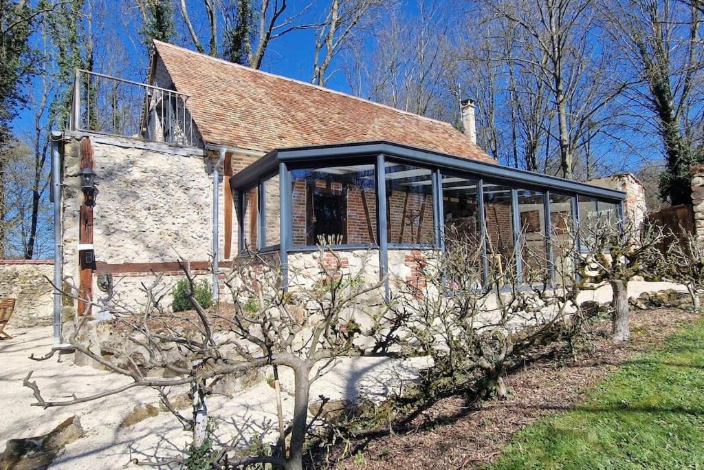 una antigua casa de piedra con un grupo de ventanas en Jardins de Mélusine - Maison en pierres 