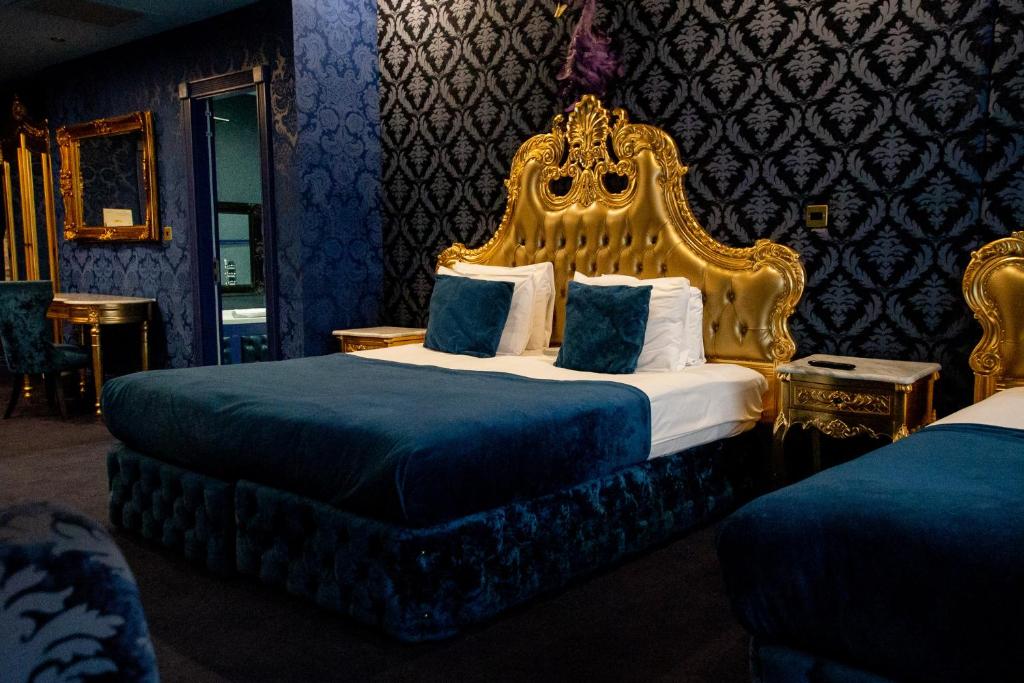 a bedroom with a large bed with a gold headboard at The Dixie Dean Hotel in Liverpool
