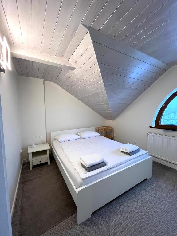 um quarto com uma cama branca e uma janela em Apartamenty Wałowa 7a - ap. Słoneczny em Lańcut
