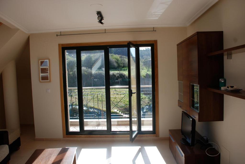 Habitación con una gran puerta de cristal con vistas. en APARTAMENTO ESPASANTE, en Porto de Espasante