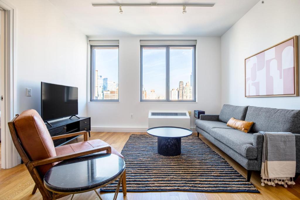 a living room with a couch and a tv at Hells Kitchen 1BR w Doorman nr Central Park NYC-525 in New York