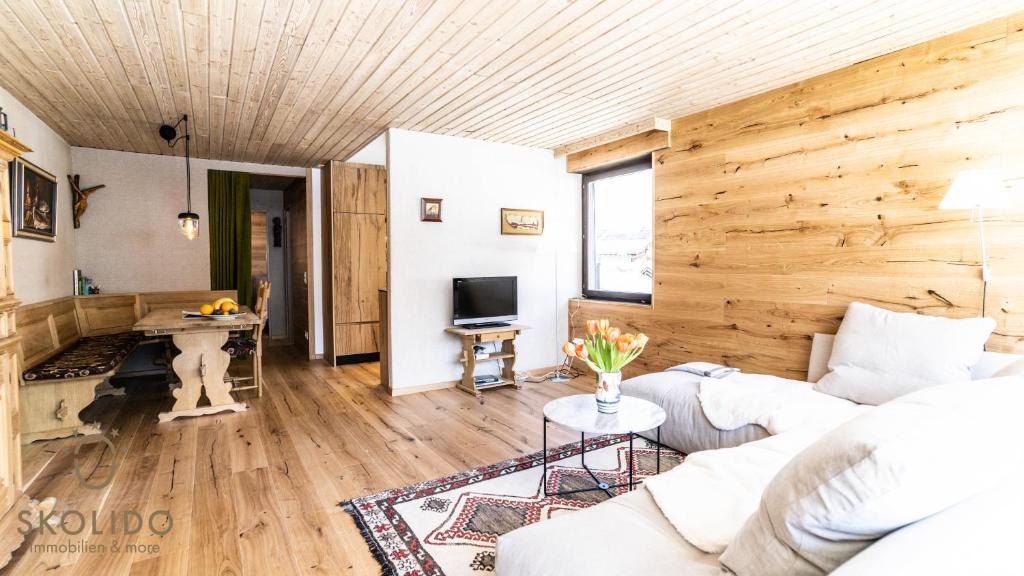 a living room with a white couch and a wooden wall at Haus Camillo in Saas-Fee