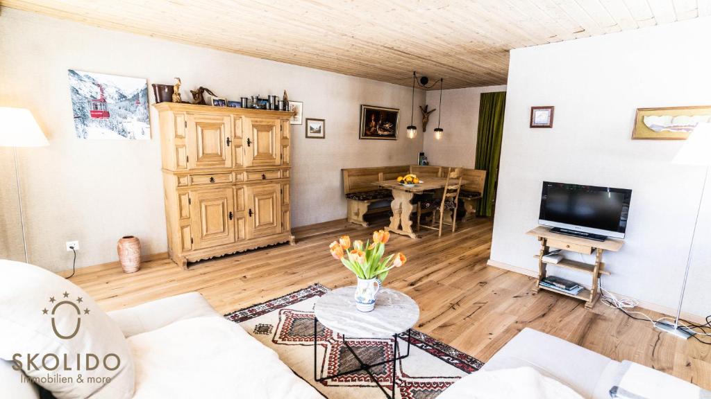 a living room with a couch and a tv at Haus Camillo in Saas-Fee