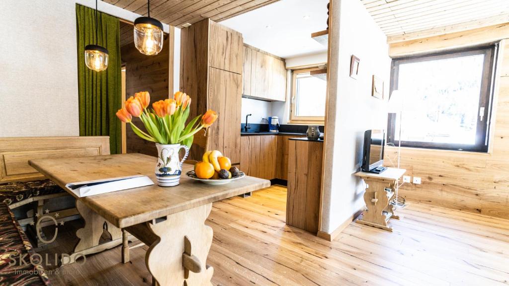 a kitchen with a table with a vase of flowers at Haus Camillo in Saas-Fee