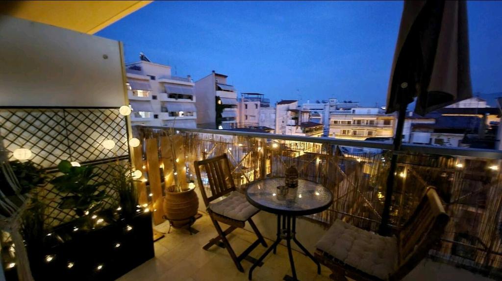uma varanda com mesa, cadeiras e luzes em Lamia - Premium apartment em Lamía