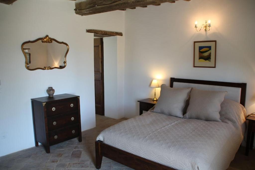 une chambre avec un lit, une commode et un miroir dans l'établissement Torricella, à Città di Castello