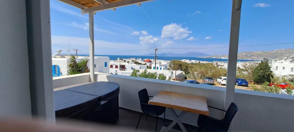 a balcony with a table and a view of a city at Fabrica Sunset Apartments in Megali Ammos