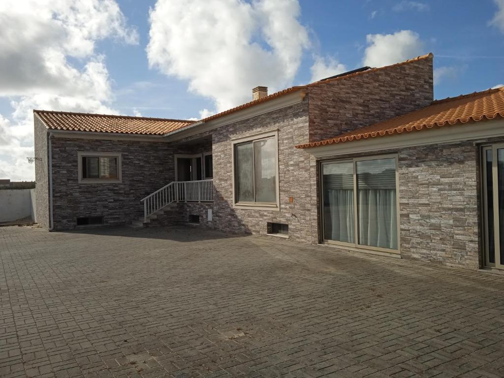 a brick house with a driveway in front of it at O Galito in Praia de Mira