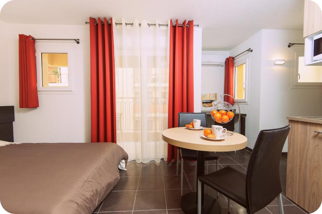 a small room with a bed and a table with a bowl of fruit at Villa Serafina Apartements in Nice