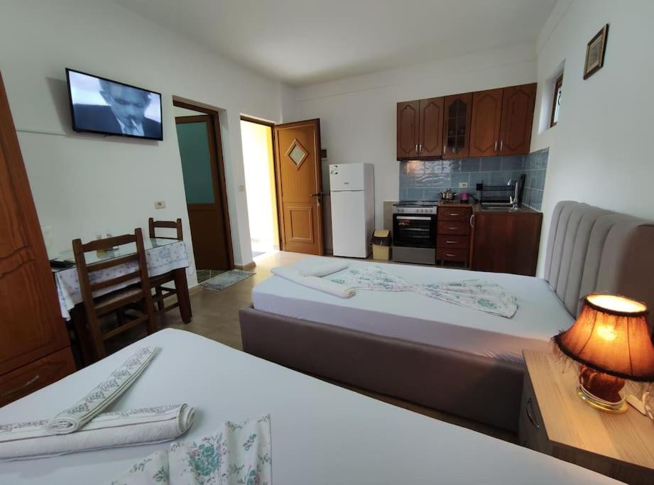 um quarto com 2 camas e uma pequena cozinha em Dona's Studio Apartment em Gjirokastër