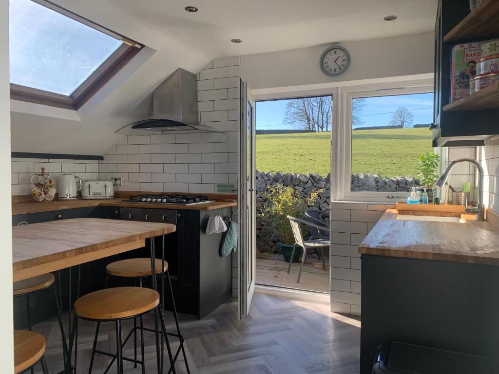 a kitchen with a counter and a window with a view at Primrose Cottage - Tideswell, Peak District in Tideswell