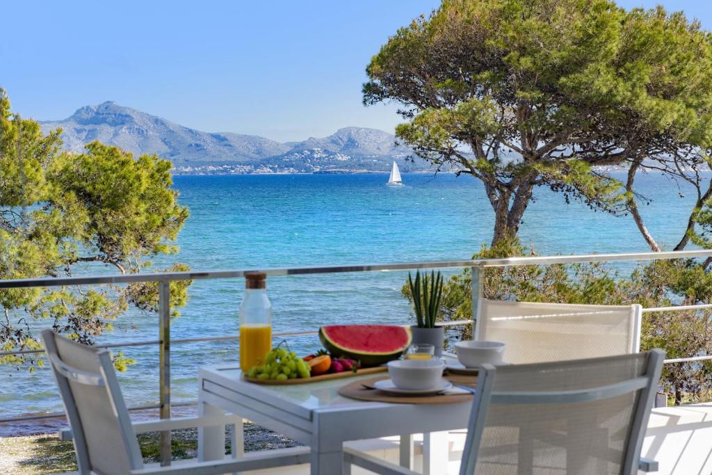 a table with a bowl of fruit and a view of the ocean at Apartamento Oratge 3 in El Port