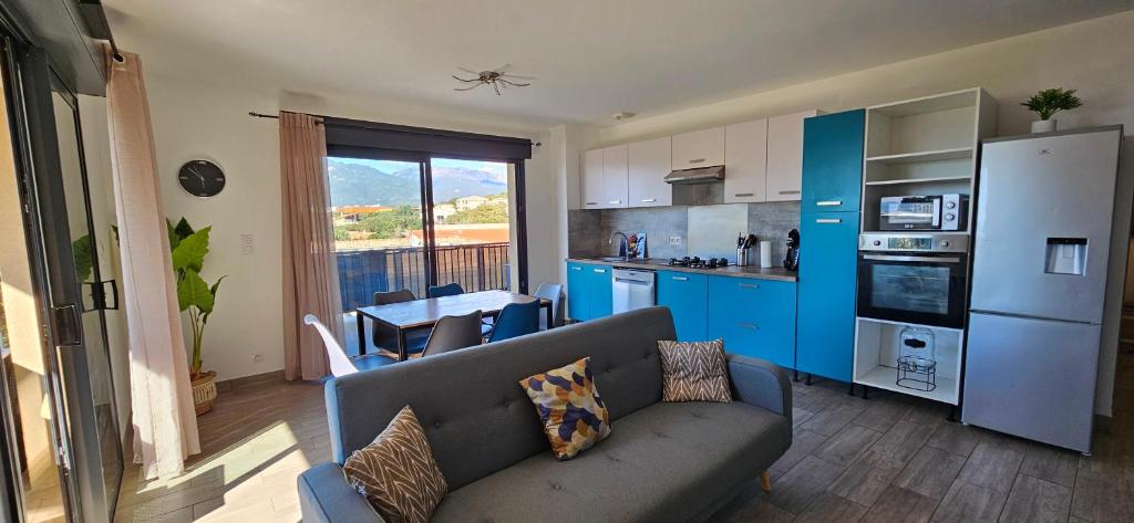 un salon avec un canapé et une cuisine dans l'établissement T3 Le Myrte vue Mer & Montagne idéalement situé, à Propriano