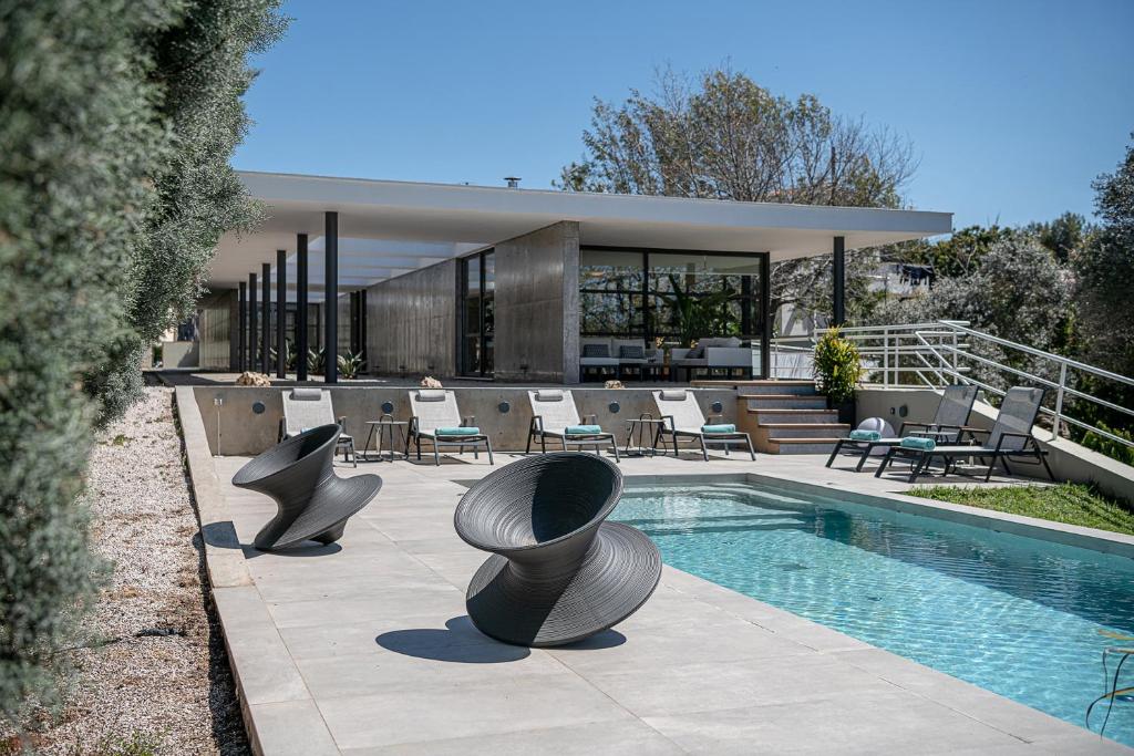 a house with a swimming pool and some chairs at Villa 7 in Perivólia