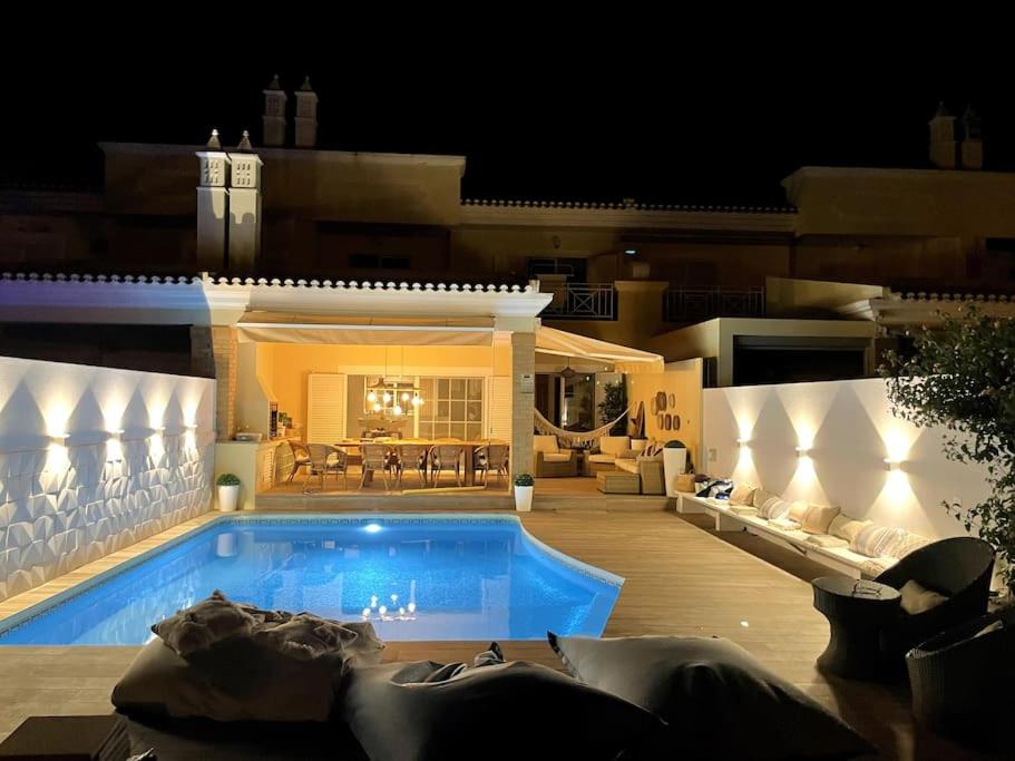 a house with a swimming pool at night at Vivenda em Vilamoura Marina Ténis Academy in Vilamoura