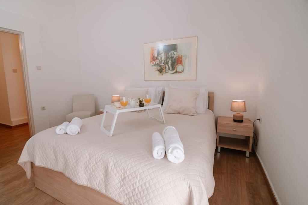 a bedroom with a white bed with a table on it at Luxury apartment, in Heraklion in Heraklio