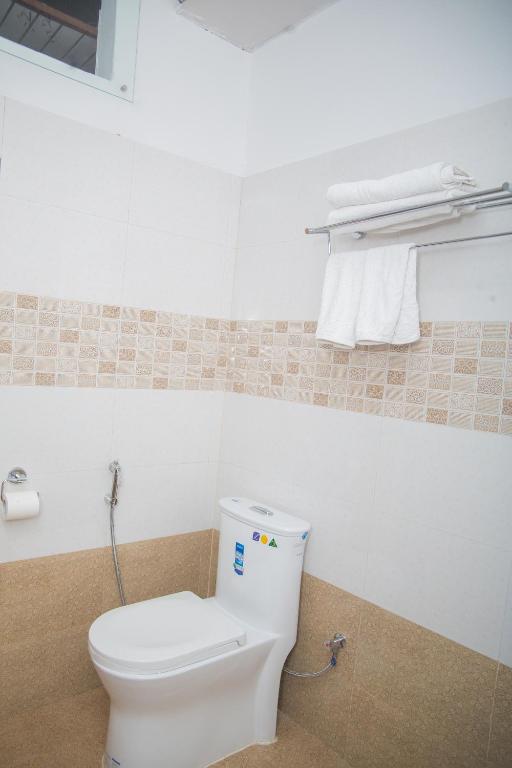 a bathroom with a toilet and towels in it at Hotel Span in Butwāl