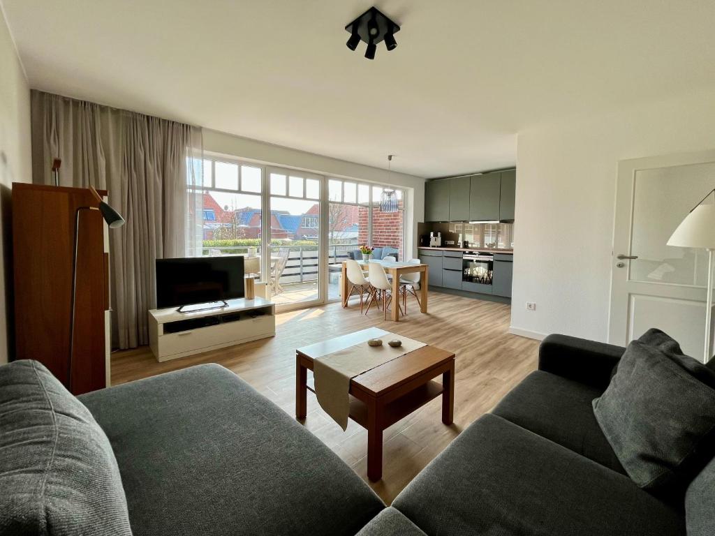 ein Wohnzimmer mit einem Sofa und einem Tisch in der Unterkunft DünePur in Norderney