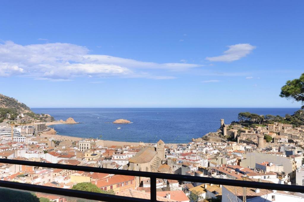 a view of a city and the ocean from a balcony at Pool and sea views apartment with 1 parking space in Tossa de Mar