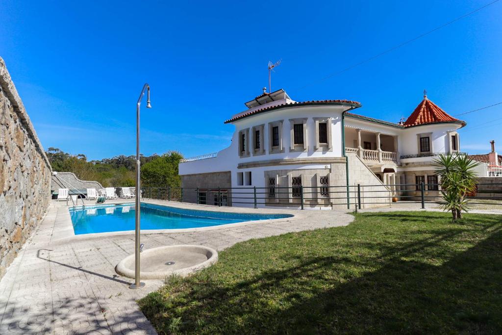 uma casa grande com uma piscina em frente em Casa do Calejo em Viana do Castelo