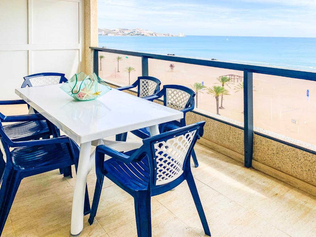 a table and chairs on a balcony with the beach at ESPACIO 8 - Primera Línea de Playa in Cullera
