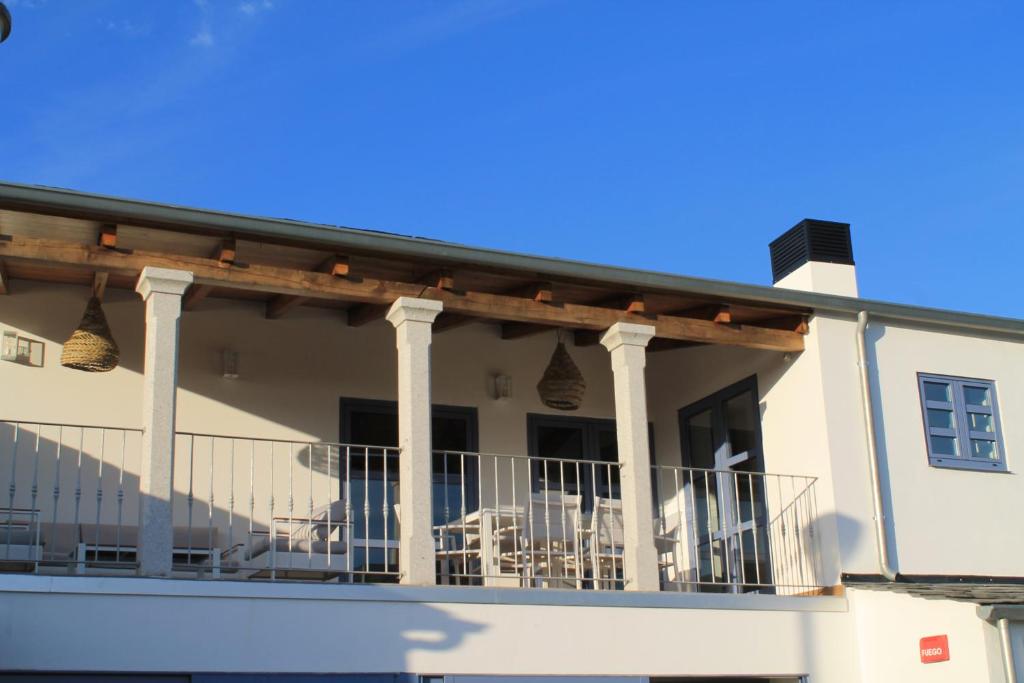 een huis met een balkon met tafels en stoelen bij CASAS DA FORTALEZA Casa da Solaina in Outeiro de Rei