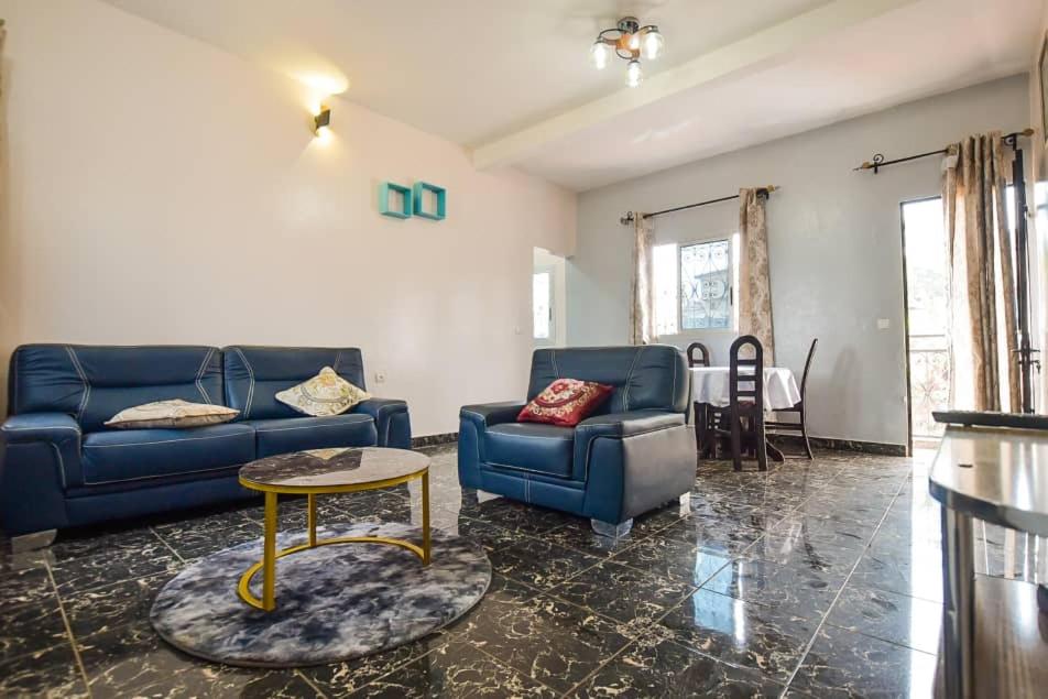 uma sala de estar com dois sofás azuis e uma mesa em Appartements Neuf de Haut Standing DM & NG à Bafoussam em Bafoussam