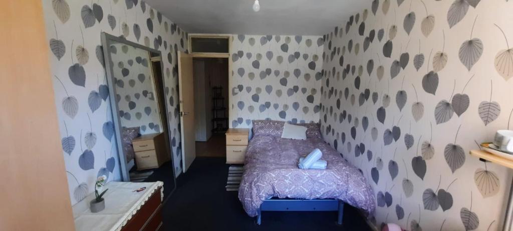 a bedroom with a bed with a purple comforter at Sublime Jadwin, Liverpool Lime City in Liverpool