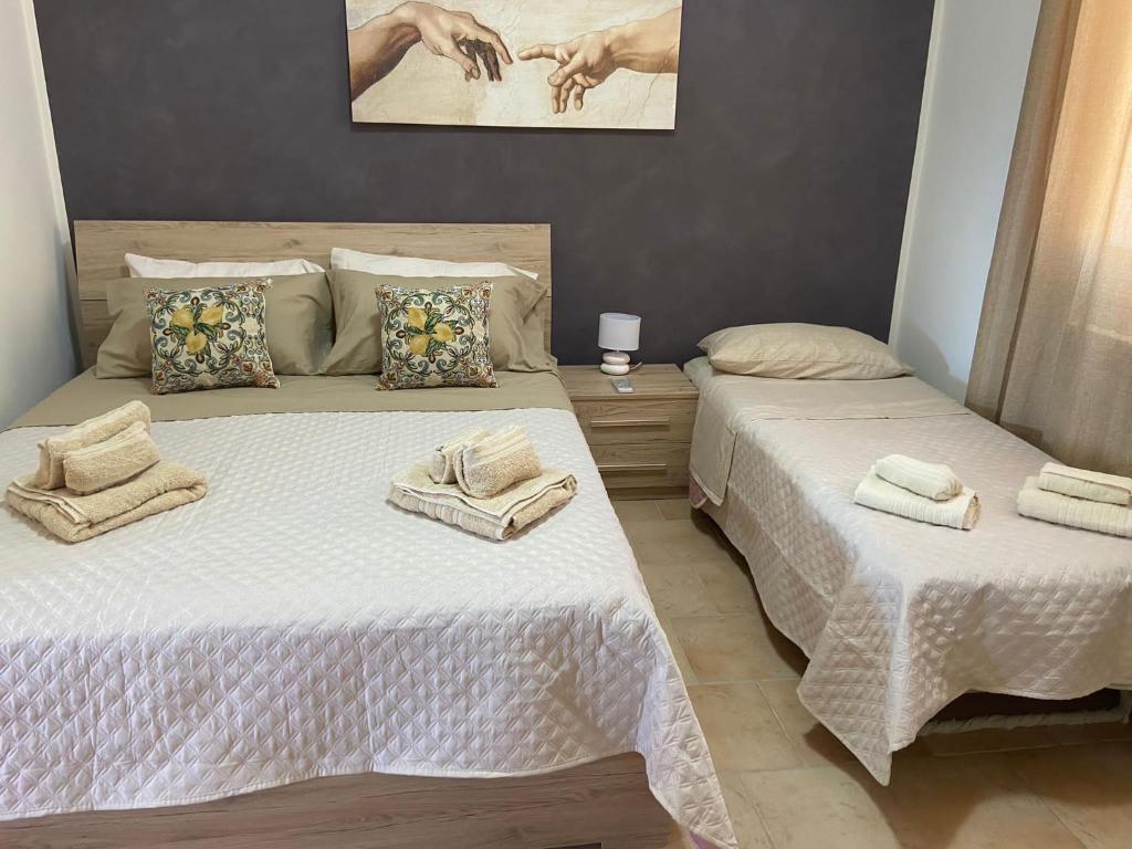 two beds sitting next to each other in a bedroom at L'Oasi dell'Eremita in Mondello