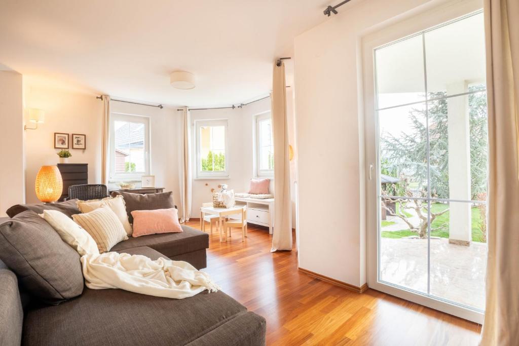 sala de estar con sofá y puerta abierta en Alpine apartments Marcella, en Žirovnica