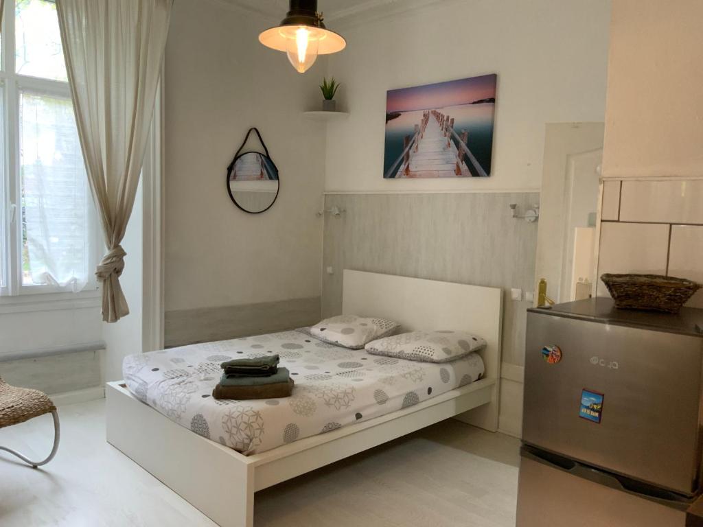 - une petite chambre avec un lit et un réfrigérateur dans l'établissement Studio centre ville, à Aix-les-Bains