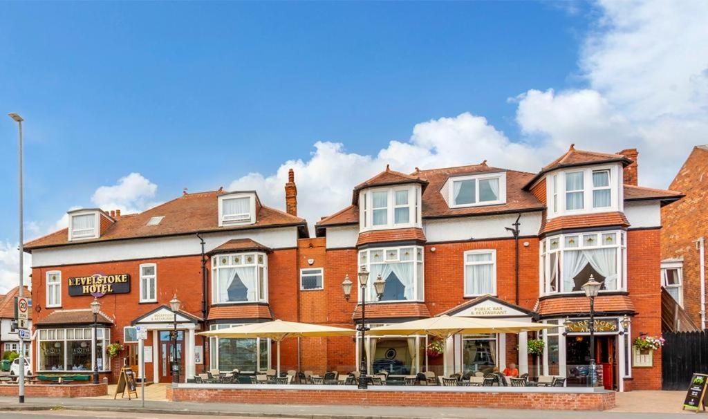 a large red brick building on a city street at Revelstoke Hotel in Bridlington