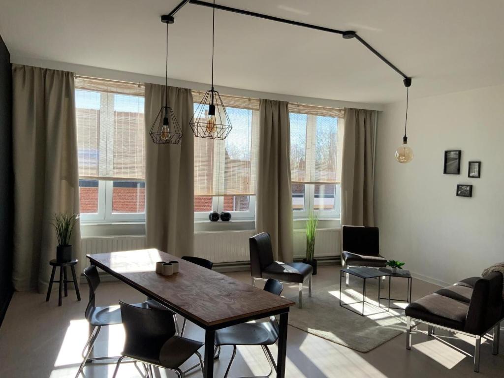 uma sala de estar com uma mesa de jantar e cadeiras em Very cozy apartment, located in the heart of Herentals em Herentals
