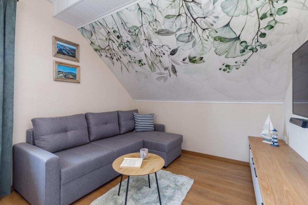 a living room with a couch and a table at Marina & Amber Grzybowo Apartments with Garden by Renters in Grzybowo