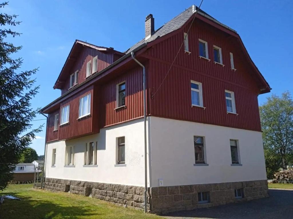 una casa grande con fachada en rojo y blanco en OK FERIEN - Altes Bahnhaus, en Muldenhammer