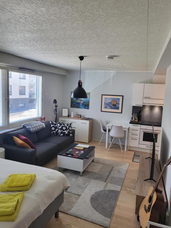 ein Wohnzimmer mit einem Sofa und einem Tisch in der Unterkunft Cozy studio in the city center in Rovaniemi