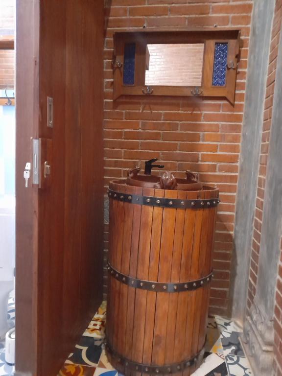 a wooden barrel in a room with a brick wall at Krobyongan staycation kalaras in Karanganyar