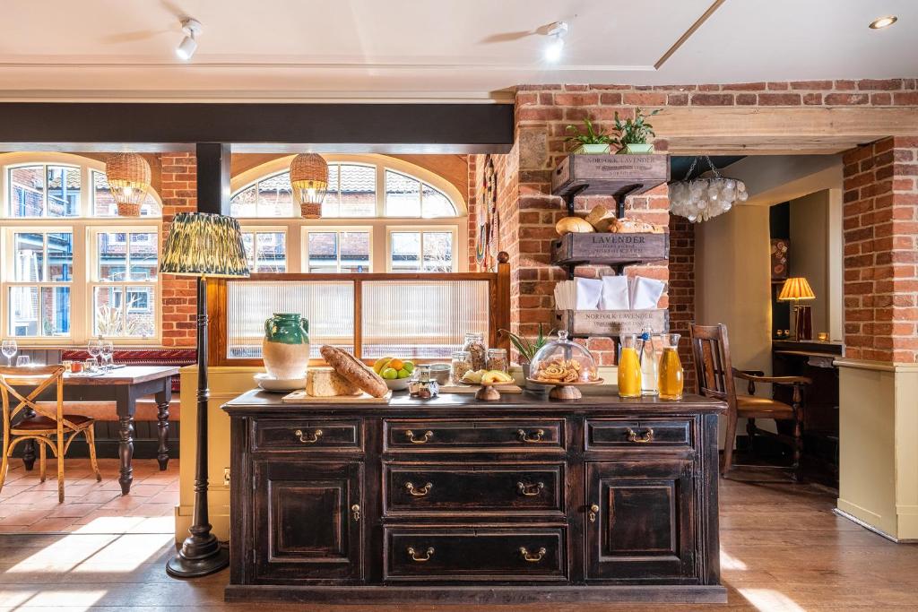 a kitchen with a large wooden cabinet with food on it at The Globe Inn in Wells next the Sea