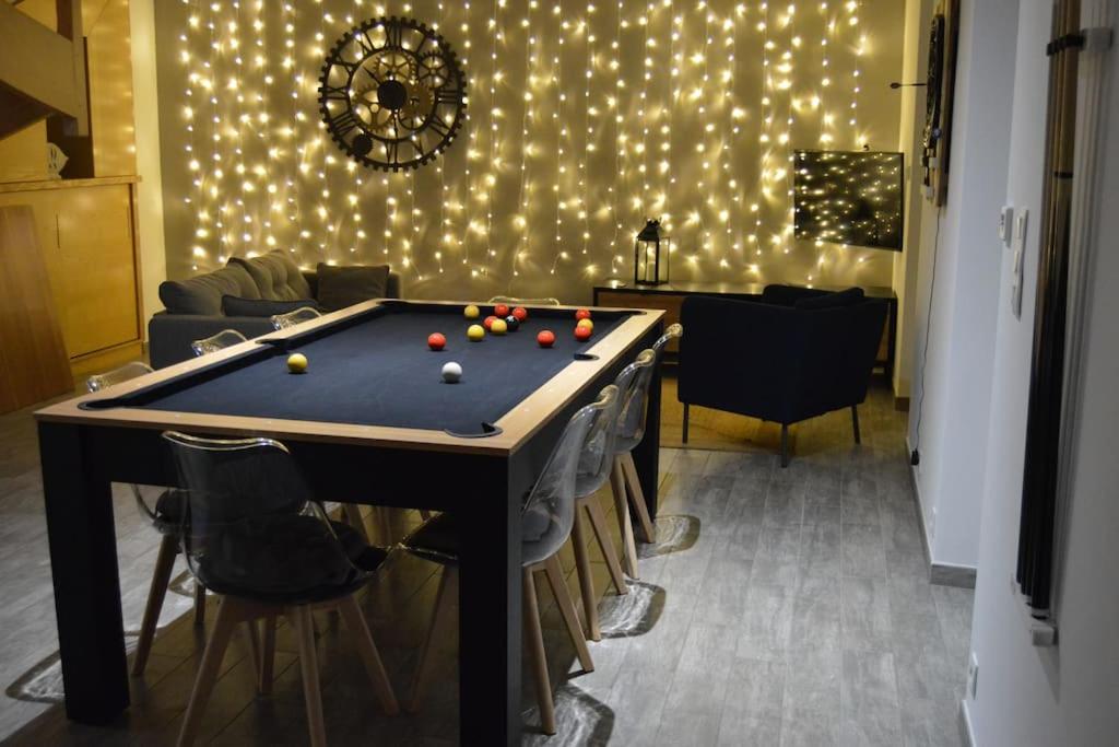 a pool table in a room with lights on a wall at Duplex 6/8p centre Plouha in Plouha