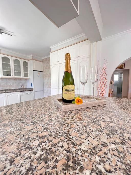 a bottle of champagne and two wine glasses on a kitchen counter at ¡Magnifica Villa Amalia! in Calpe