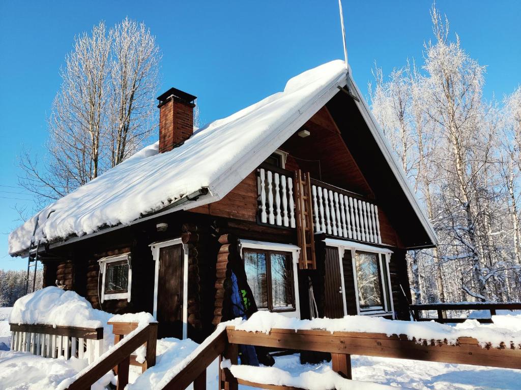 eine Blockhütte mit Schnee auf dem Dach in der Unterkunft Villa Haapala in Rovaniemi