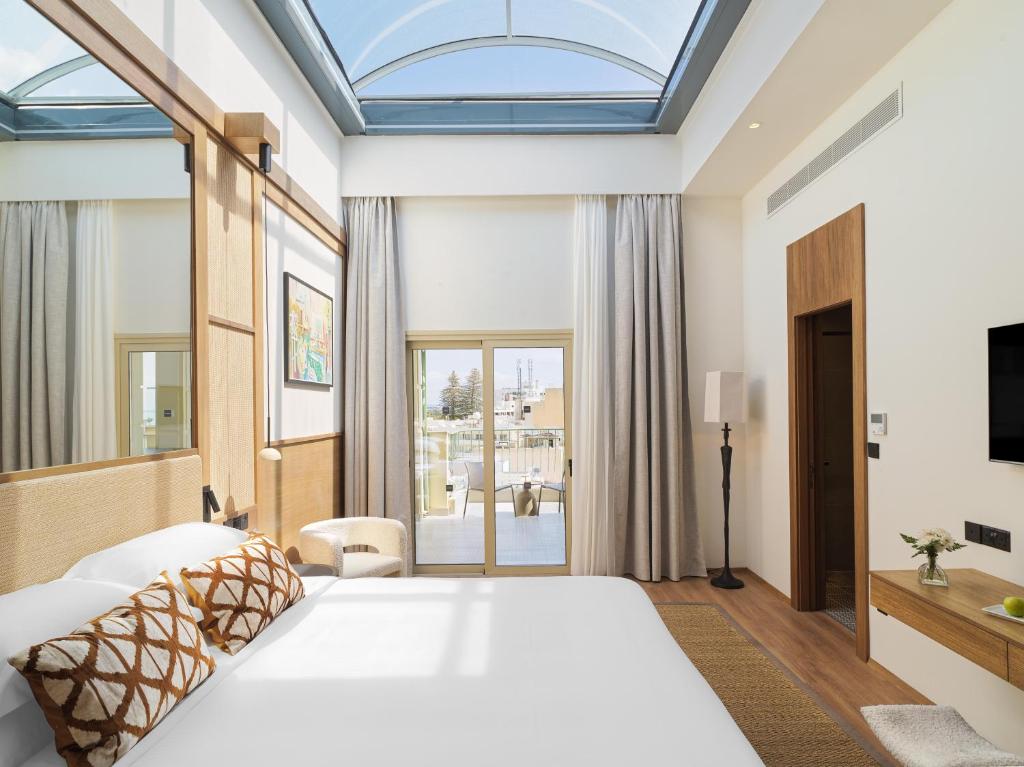 a bedroom with a large white bed and a window at Leonardo Boutique Hotel Larnaca in Larnaca