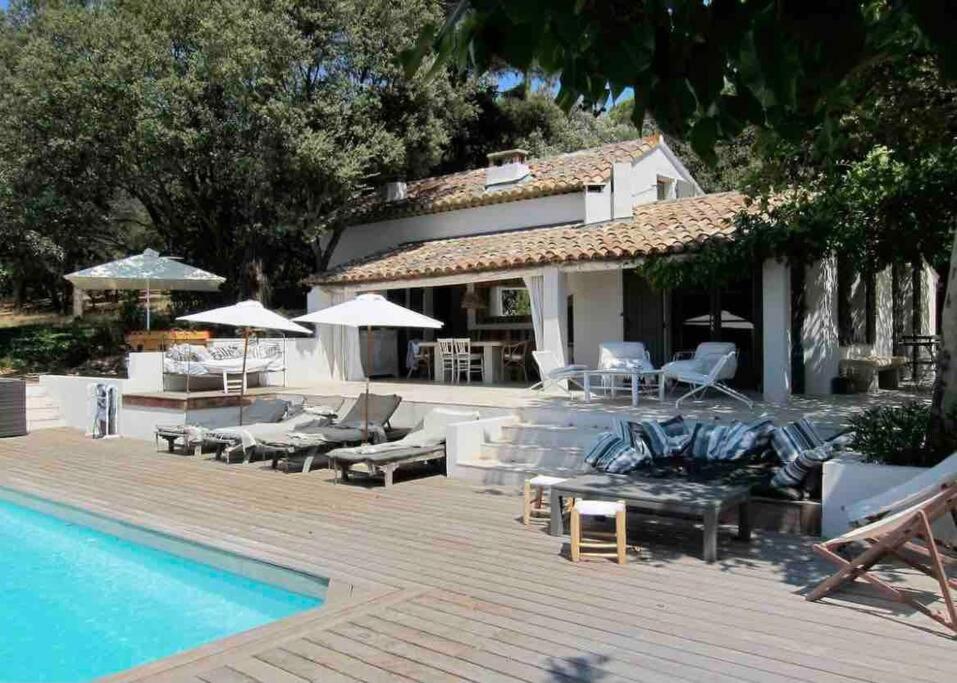 a swimming pool with lounge chairs and a house at BASTIDON FARFALLINA in Puyvert
