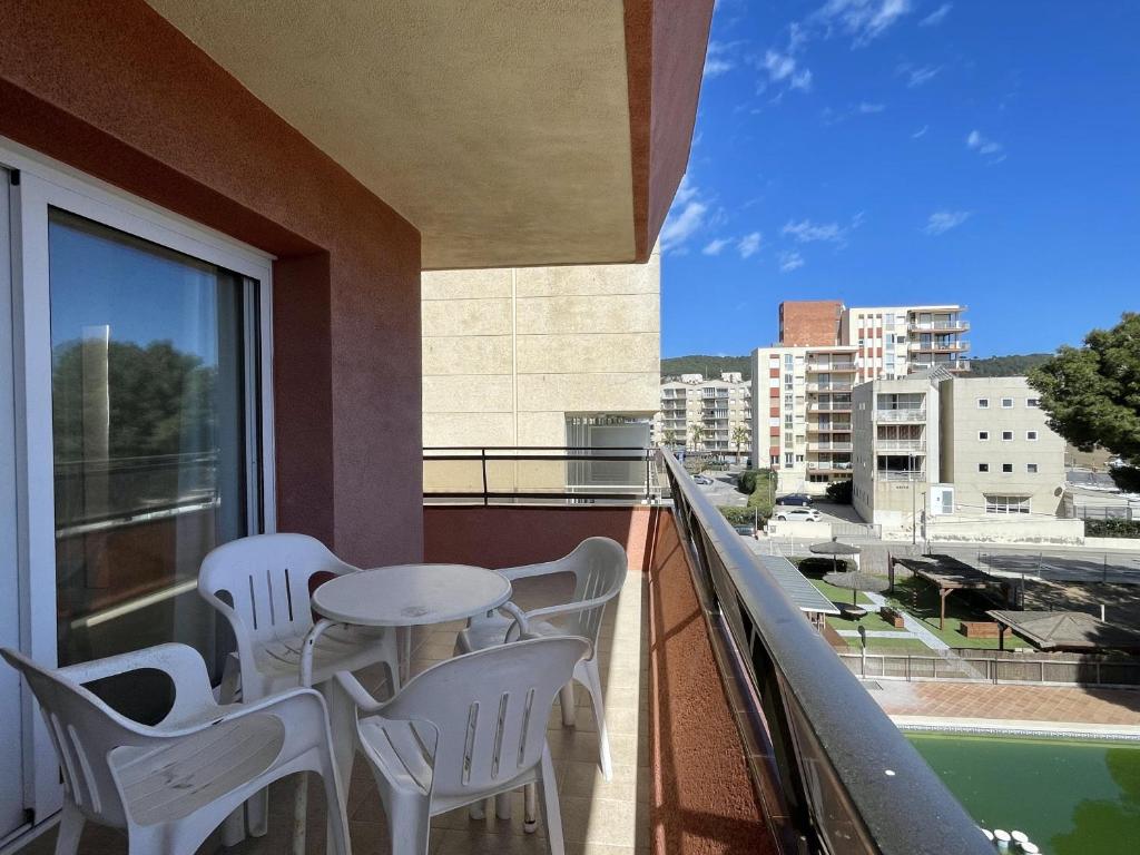 a balcony with white chairs and a table and a window at Salles Beach 33 in L'Estartit