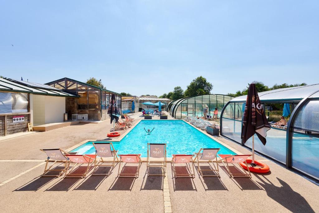 una piscina su una nave da crociera con sedie intorno di Glamping Vendée a Saint-Julien-des-Landes