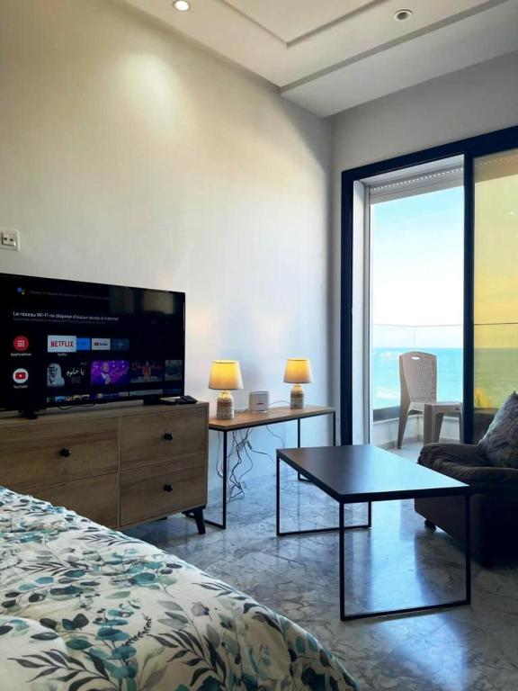 - une chambre avec un lit, une télévision et une table dans l'établissement Studio avec vue directe mer, à Monastir